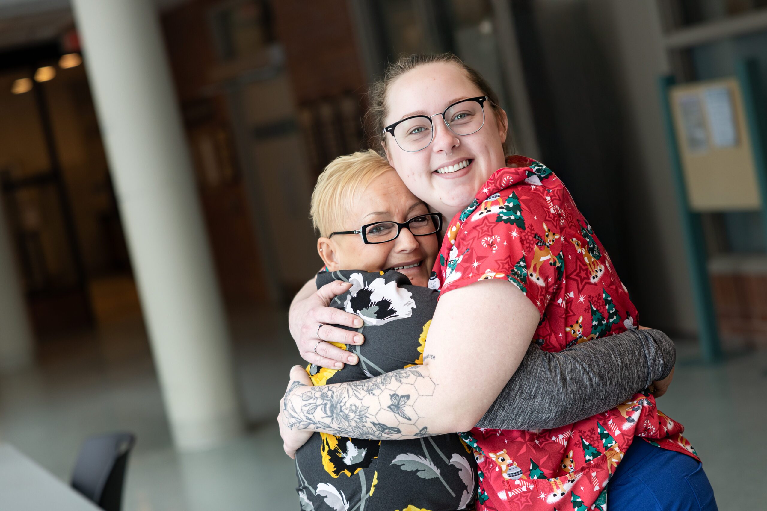 Two team members hugging and smiling.
