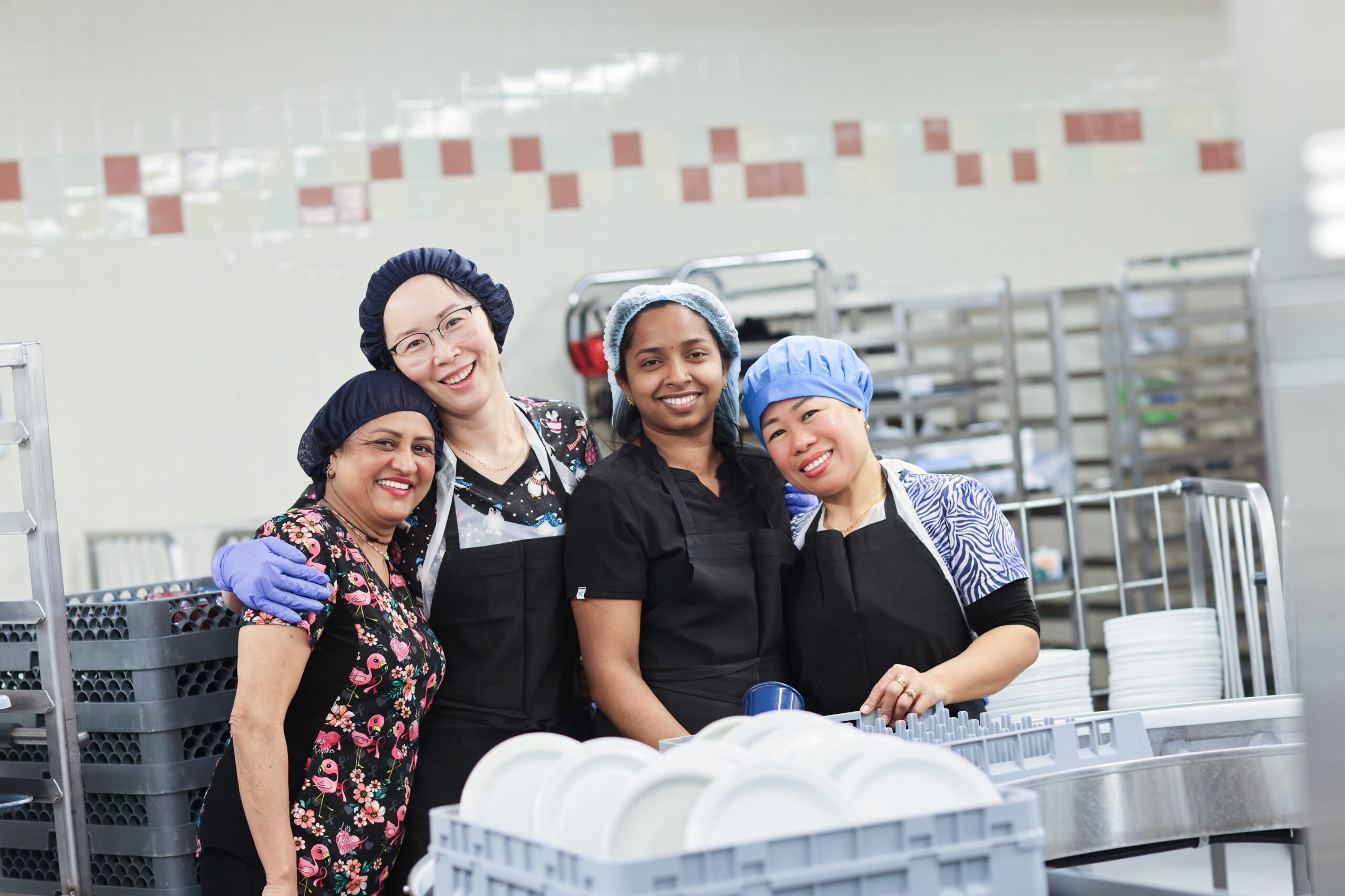 A group of food services team members smiling in one of the hospital’s kitchens.