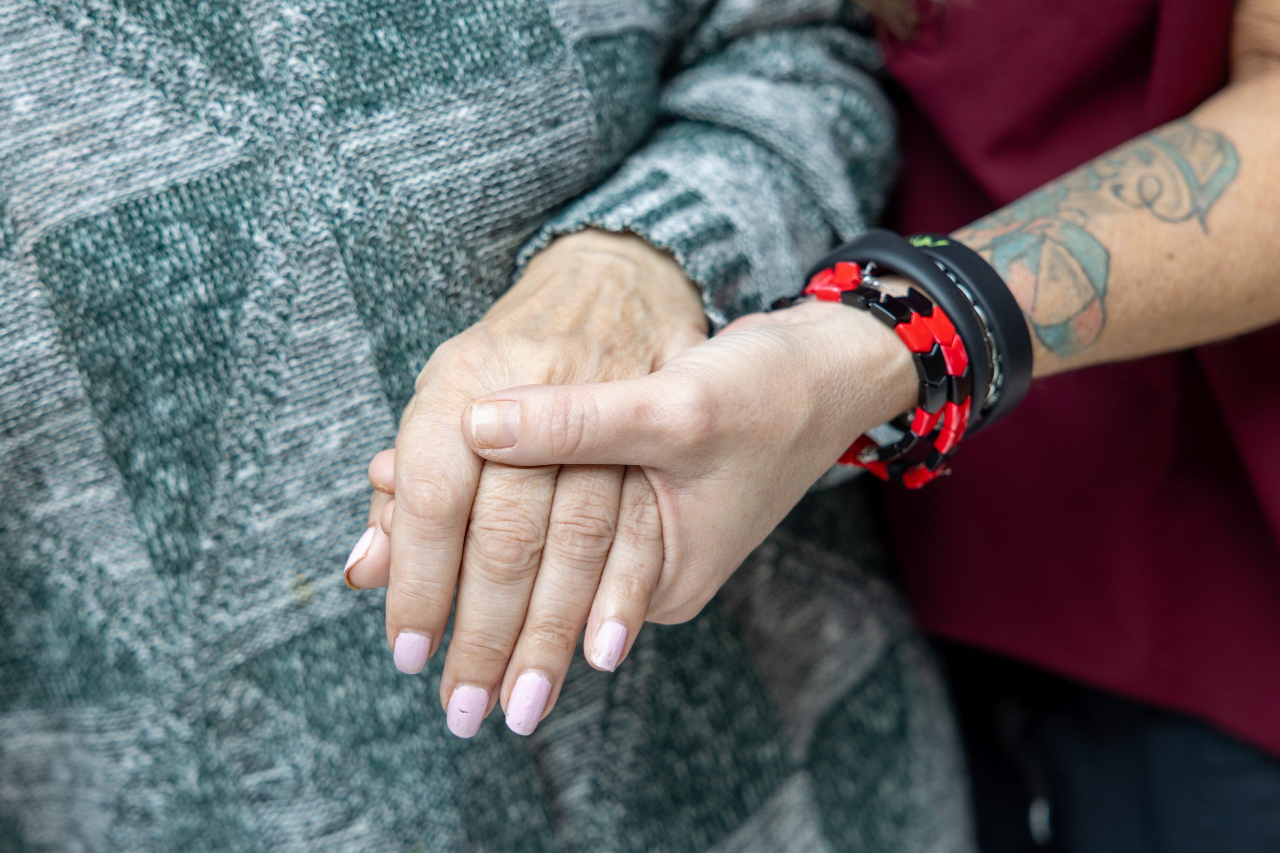 Close up on one person holding another person’s hand.
